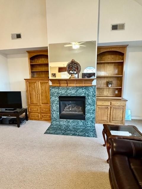 living room featuring carpet flooring, a towering ceiling, and a fireplace