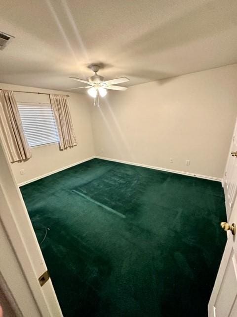 carpeted spare room featuring a textured ceiling and ceiling fan