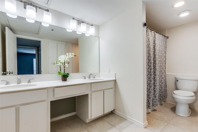 bathroom featuring tile patterned floors, toilet, vanity, and tile walls