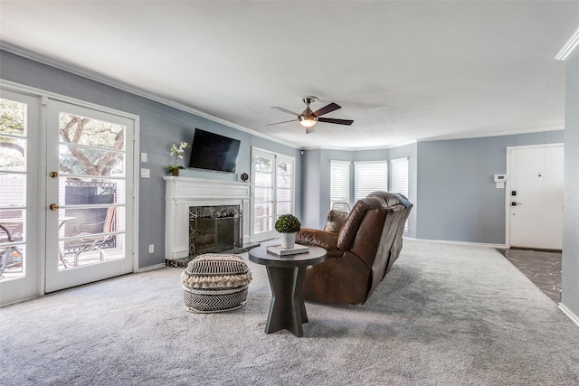 carpeted living room featuring crown molding, ceiling fan, and a premium fireplace