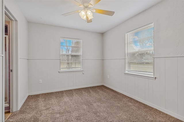 unfurnished room featuring ceiling fan and carpet