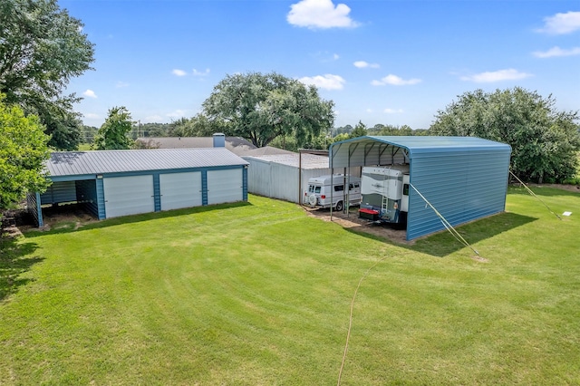 view of yard with a garage, an outdoor structure, and a carport