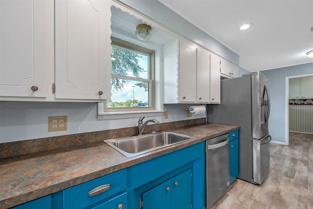 kitchen featuring blue cabinetry, stainless steel appliances, light wood-type flooring, white cabinets, and sink