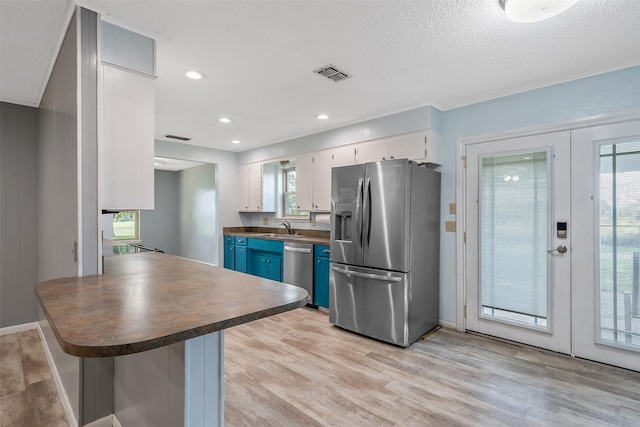 kitchen with white cabinetry, blue cabinetry, french doors, stainless steel appliances, and sink