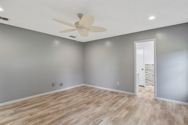 unfurnished room featuring ceiling fan, light hardwood / wood-style floors, and a textured ceiling