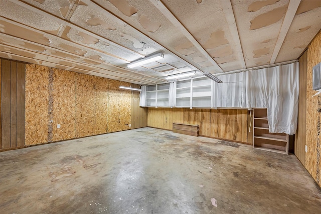 basement featuring wooden walls