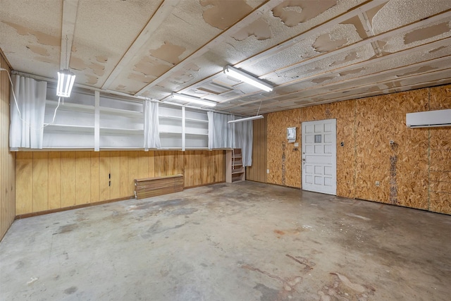 basement with a wall mounted AC and wooden walls
