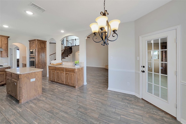 kitchen featuring appliances with stainless steel finishes, a center island, plenty of natural light, and decorative light fixtures