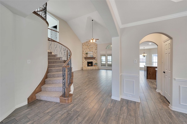 entryway featuring ceiling fan, vaulted ceiling, and a stone fireplace