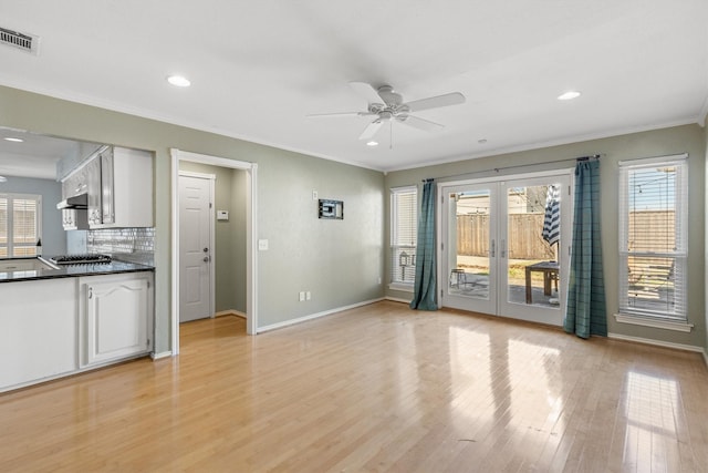 interior space featuring a healthy amount of sunlight, french doors, crown molding, and light hardwood / wood-style floors