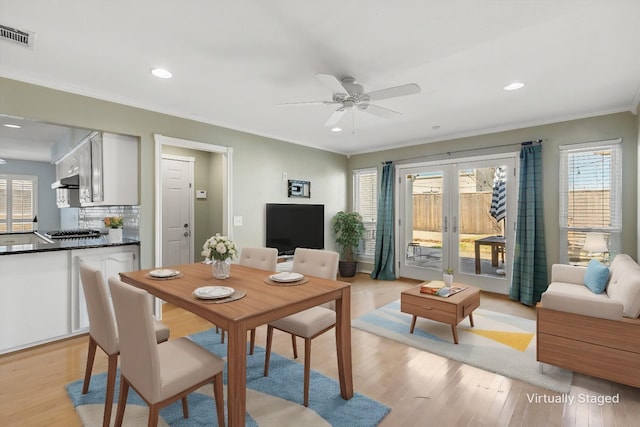 dining area featuring light hardwood / wood-style floors, french doors, crown molding, and ceiling fan