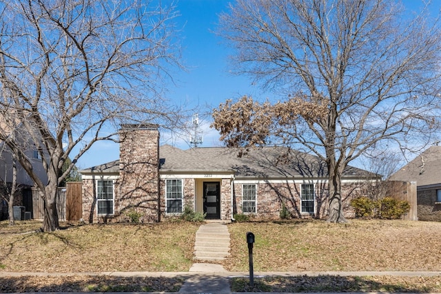 view of front of home with central AC unit and a front lawn