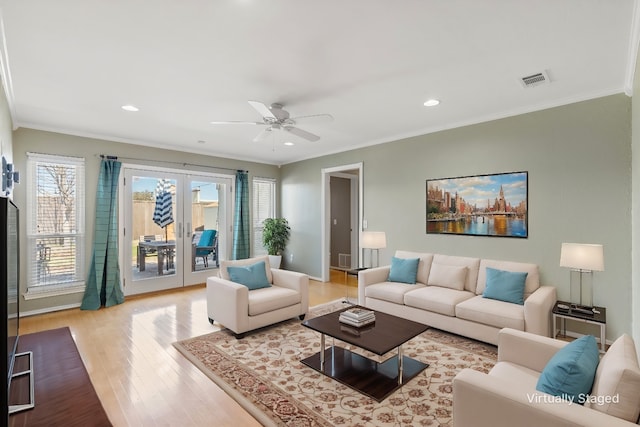 living room featuring french doors, ornamental molding, ceiling fan, and light hardwood / wood-style flooring