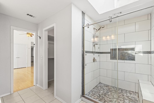 bathroom with a shower with door and tile patterned floors