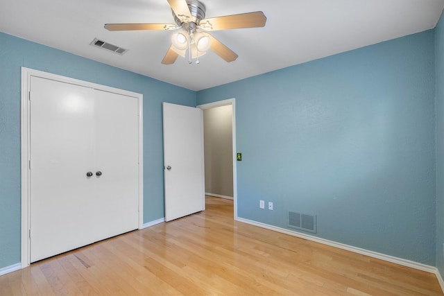 unfurnished bedroom featuring ceiling fan, light hardwood / wood-style flooring, and a closet