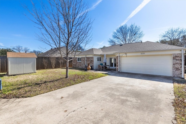 ranch-style home with a storage unit, a front lawn, and a garage