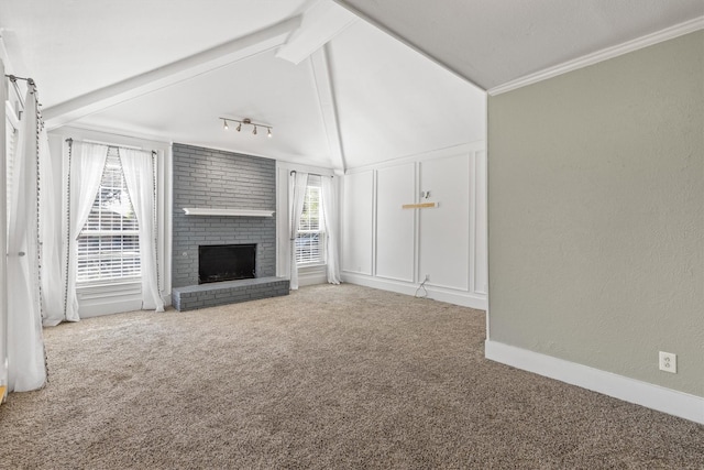 unfurnished living room with ornamental molding, carpet flooring, a brick fireplace, and lofted ceiling with beams