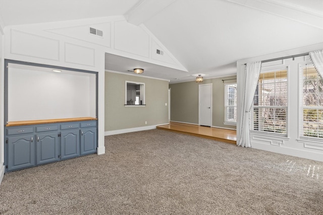 interior space featuring beamed ceiling, crown molding, carpet floors, and high vaulted ceiling