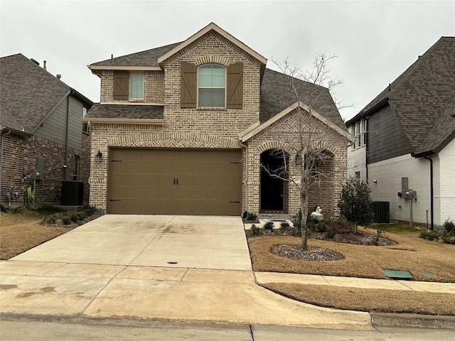 view of front of property featuring central AC unit and a garage