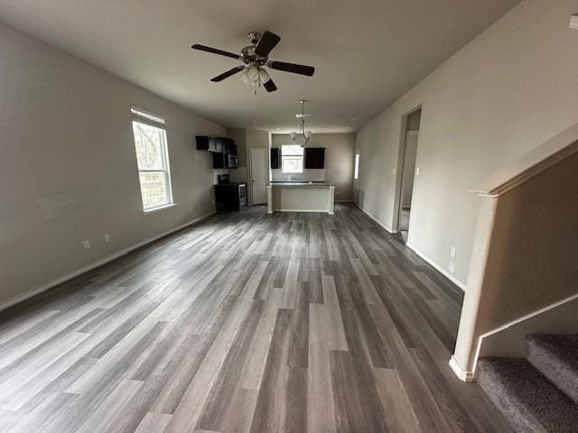 unfurnished living room featuring ceiling fan and dark hardwood / wood-style floors