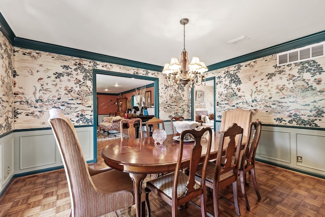 dining room featuring ornamental molding, a notable chandelier, and dark parquet floors