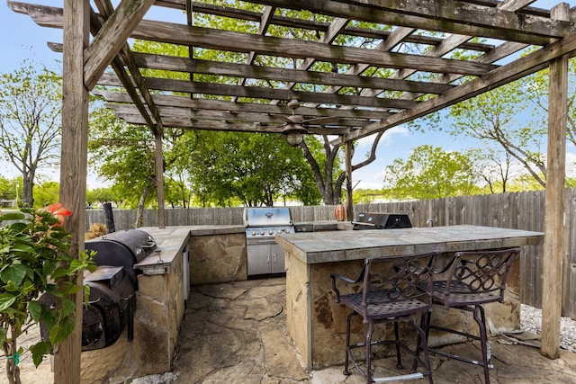 view of patio featuring area for grilling, a pergola, and a bar