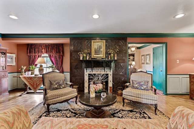 sitting room with a premium fireplace and crown molding