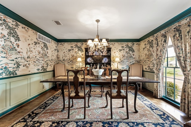 dining room with ornamental molding, dark parquet floors, and an inviting chandelier