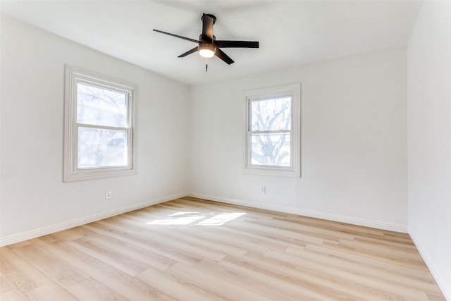 spare room with ceiling fan, light wood-type flooring, and a healthy amount of sunlight