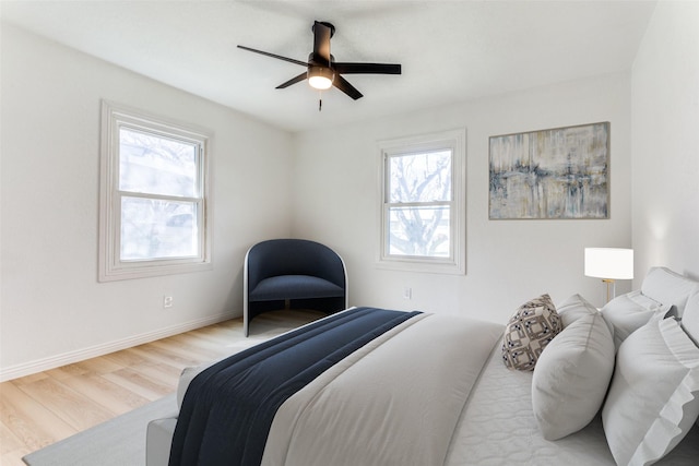 bedroom featuring multiple windows, light hardwood / wood-style flooring, and ceiling fan