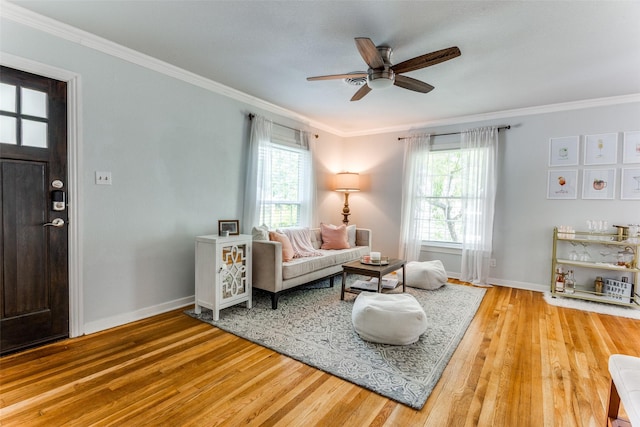 sitting room featuring light wood-type flooring, a wealth of natural light, and crown molding