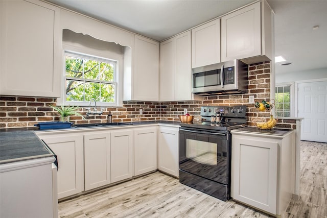 kitchen featuring white cabinetry, black range with electric stovetop, light hardwood / wood-style flooring, sink, and tasteful backsplash