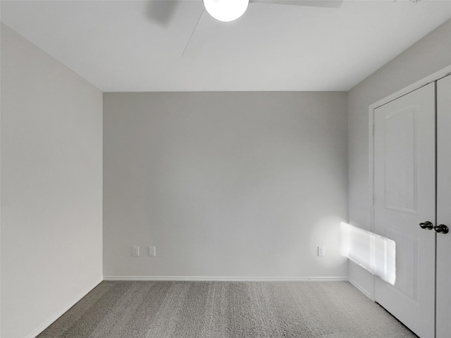 unfurnished room with carpet, baseboards, and a ceiling fan