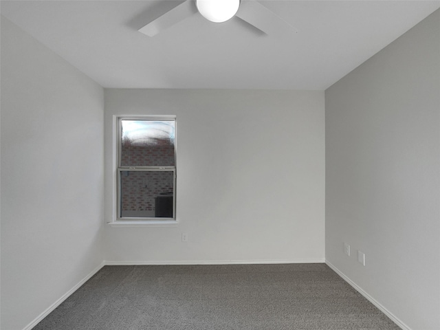 carpeted spare room featuring ceiling fan and baseboards