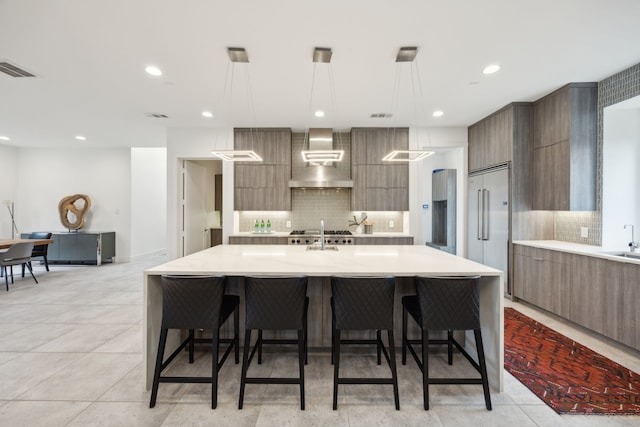 kitchen featuring modern cabinets, a kitchen breakfast bar, light countertops, and decorative light fixtures