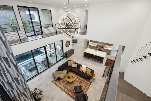 living area featuring stairs, recessed lighting, tile patterned flooring, and an inviting chandelier