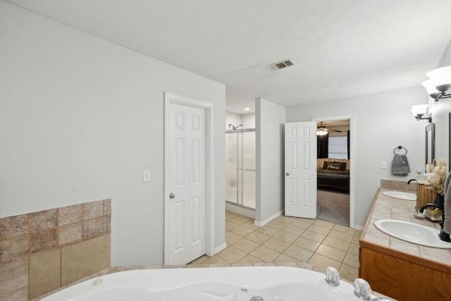 ensuite bathroom with double vanity, visible vents, a sink, a jetted tub, and tile patterned floors