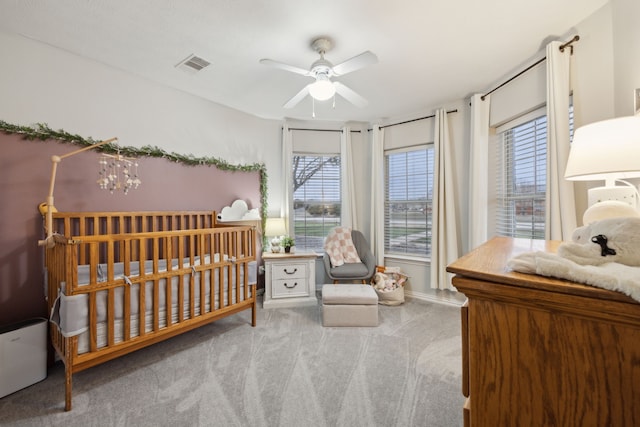 bedroom with ceiling fan with notable chandelier, light colored carpet, visible vents, and multiple windows