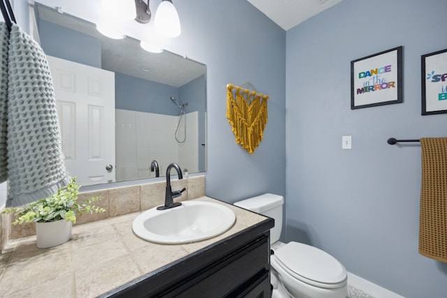 bathroom with toilet, baseboards, a shower, and vanity