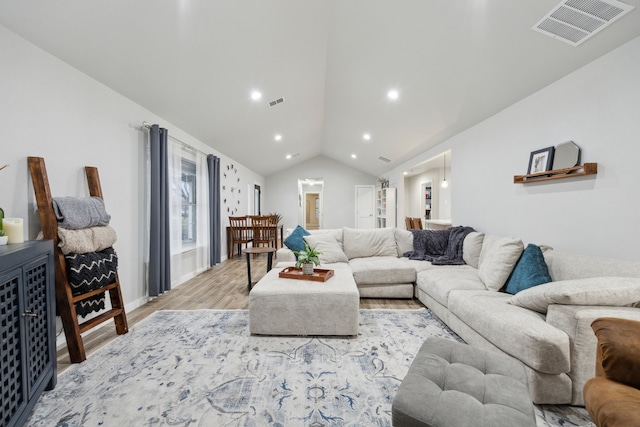 living room with lofted ceiling, recessed lighting, visible vents, and light wood-style floors