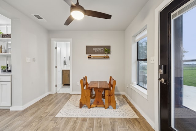 dining space with light wood-type flooring, baseboards, visible vents, and ceiling fan