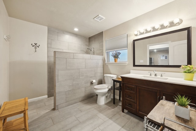 full bath with baseboards, visible vents, toilet, vanity, and a walk in shower