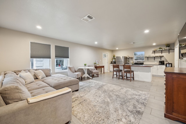 living area with recessed lighting, a healthy amount of sunlight, and visible vents