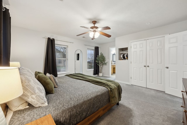 bedroom with baseboards, ceiling fan, ensuite bathroom, carpet floors, and a closet