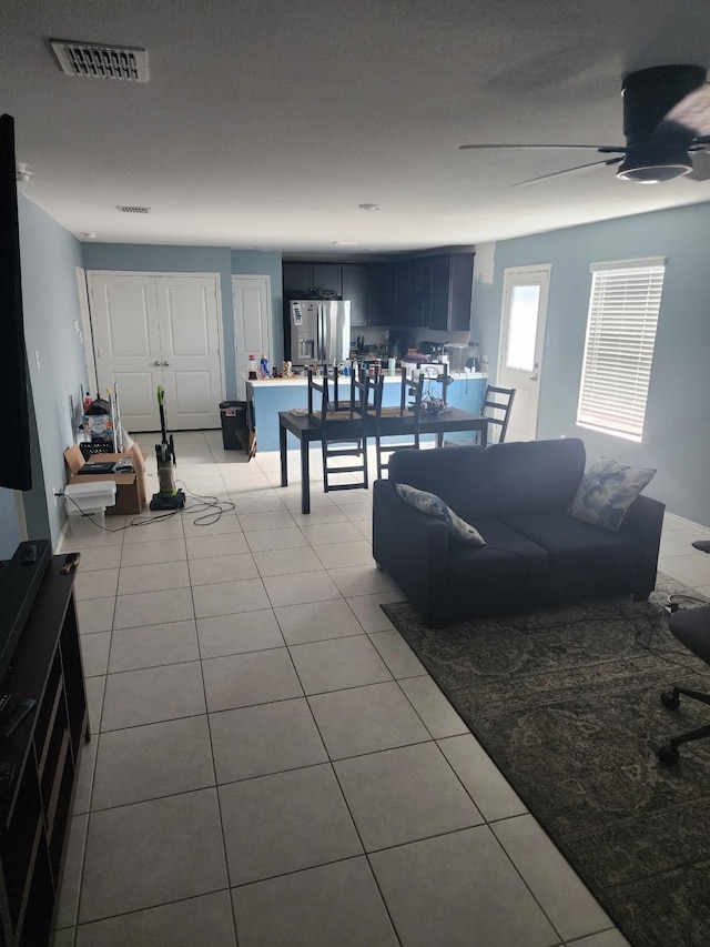 tiled living room featuring ceiling fan