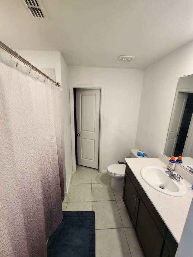 bathroom with vanity, toilet, and tile patterned floors