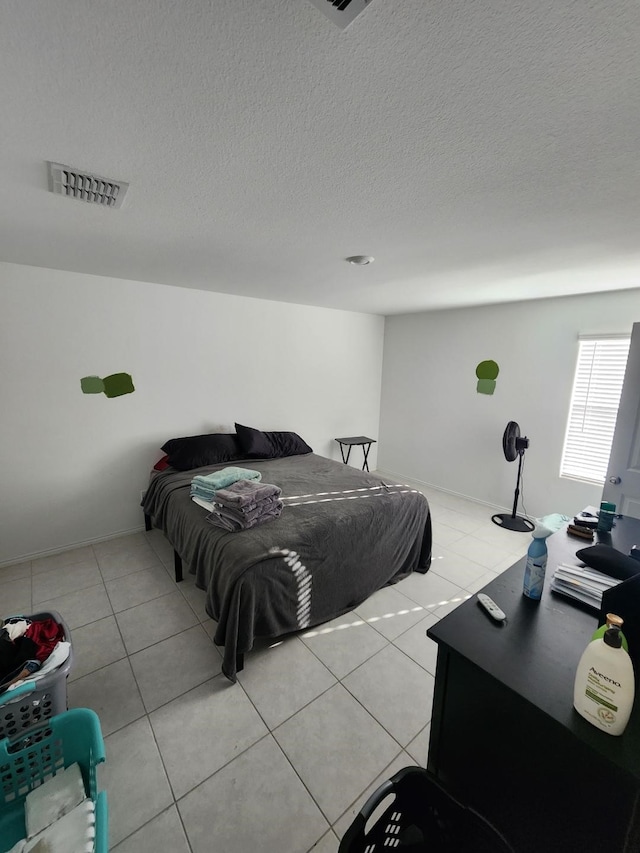 bedroom featuring light tile patterned flooring and a textured ceiling