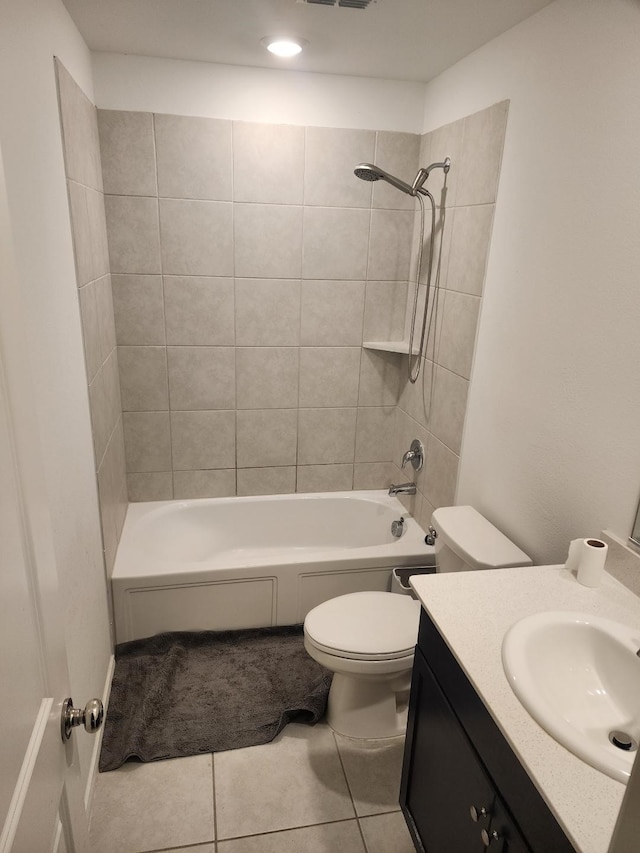 full bathroom with tiled shower / bath combo, toilet, tile patterned flooring, and vanity