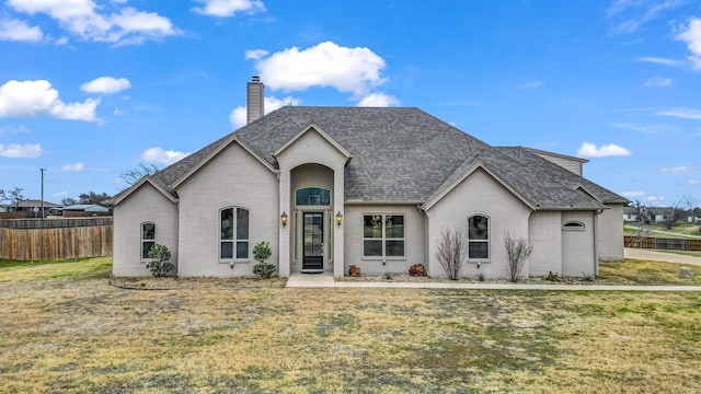 french country inspired facade with a front lawn