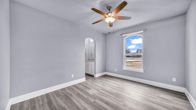 114 N Star Crossing Ln, Weatherford, TX 76088 - unfurnished room featuring ceiling fan, baseboards, arched walkways, and wood finished floors